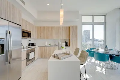 a kitchen with a refrigerator and a table with chairs at 3900-602LG DESIGN DISTRICT, CONDO 2 BEDROOMS & 2 BATHROOMS in Miami