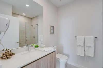 a white bathroom with a sink and a toilet at 3900-602LG DESIGN DISTRICT, CONDO 2 BEDROOMS & 2 BATHROOMS in Miami