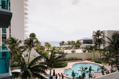a view of the pool and beach from the balcony of a resort at Sian Oceanfront Condos in Hollywood