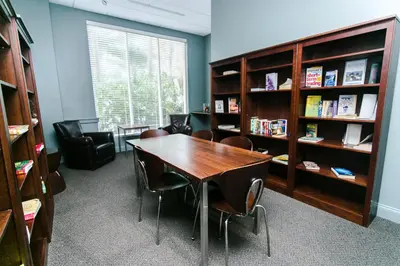 a library with a table and chairs and book shelves at Sian Oceanfront Condos in Hollywood