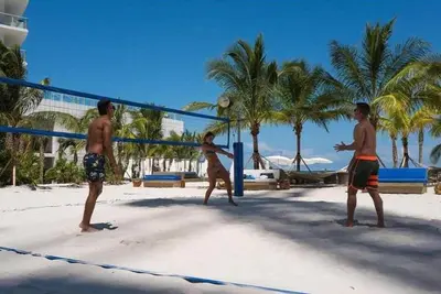 three men playing a game of volleyball on the beach at Sian Oceanfront Condos in Hollywood