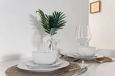 a table with plates and glasses and a plant at The Perfect Escape @Lake Ridge in Fort Lauderdale
