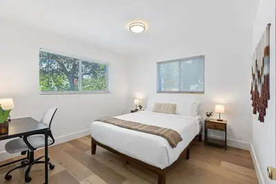a bedroom with a bed and a desk and two windows at The Perfect Escape @Lake Ridge in Fort Lauderdale