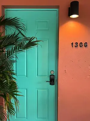 a green door with a sign on a wall at Charming cozy studio @ Lake Ridge in Fort Lauderdale