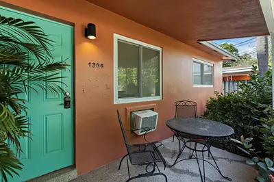 a table and chairs in front of a house with a door at Charming cozy studio @ Lake Ridge in Fort Lauderdale