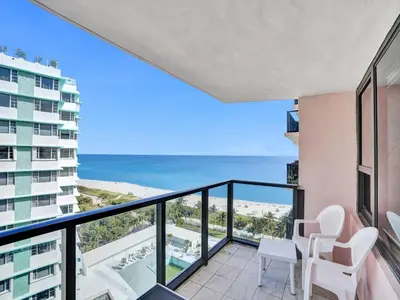 a balcony with chairs and a view of the ocean at High floor Oceanview condo 1506 in Miami Beach