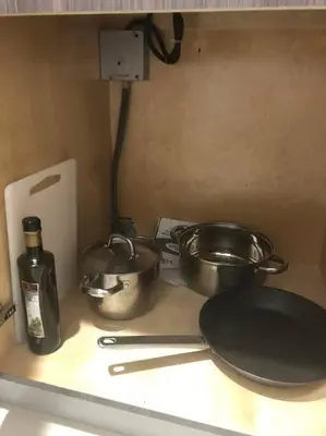 a kitchen counter with pots and pans and a bottle at Modern apartment steps the beach in Miami Beach