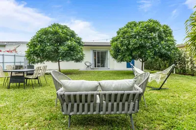 a yard with chairs and a table and a table and chairs at Hidden Garden: A Serene Miami Escape in Cutler Bay