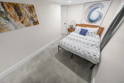 a bedroom with a bed and paintings on the wall at Progresso Apartments & Homes by Lowkl in Fort Lauderdale