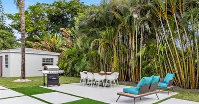 a patio with chairs and a grill and palm trees at New Spectacular 6BR Bliss - Pool - Spa & Pickell in Miami