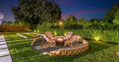 a backyard with two chairs and a fire pit at New Spectacular 6BR Bliss - Pool - Spa & Pickell in Miami