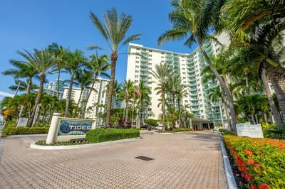 a large apartment building with palm trees in front of it at Tides in Hollywood Beach By My Miami Vacation in Hollywood