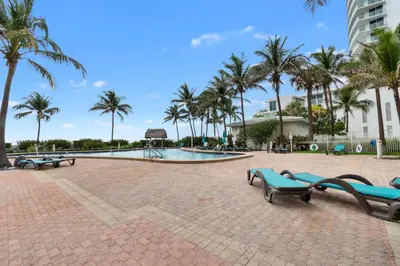 a swimming pool with palm trees and benches at Tides in Hollywood Beach By My Miami Vacation in Hollywood