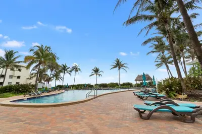 a swimming pool with chaise lounges and palm trees at Tides in Hollywood Beach By My Miami Vacation in Hollywood