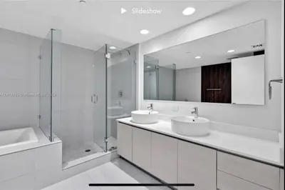 a white bathroom with two sinks and a shower at Apartment 3B/3B Bay View in Hallandale Beach