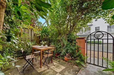 a table and chairs in a garden with a fence at Beautiful Apt in Victoria Park (Las Olas Blvd) in Fort Lauderdale