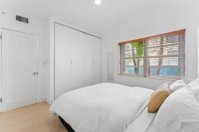 a white bedroom with a bed and a window at Beautiful Apt in Victoria Park (Las Olas Blvd) in Fort Lauderdale