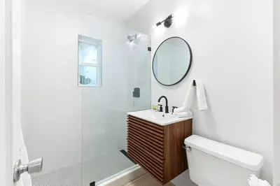 a white bathroom with a sink and a mirror at Bright and Stylish Apt in Las Olas Blvd Victoria Park in Fort Lauderdale