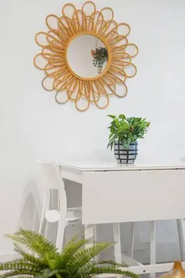 a mirror hanging above a table with a potted plant at Bright and Stylish Apt in Las Olas Blvd Victoria Park in Fort Lauderdale
