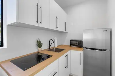 a white kitchen with a sink and a refrigerator at Mango House en Dania Beach in Dania Beach