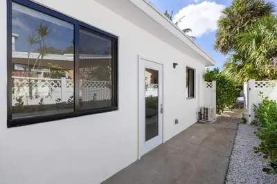a white house with large windows and a walkway at Mango House en Dania Beach in Dania Beach