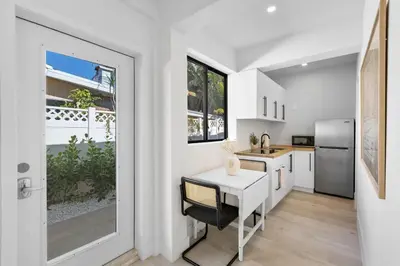 a white kitchen with a table and a refrigerator at Mango House en Dania Beach in Dania Beach