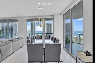 a dining room with a table and chairs and large windows at Apartment 3B/3B Bay View in Hallandale Beach