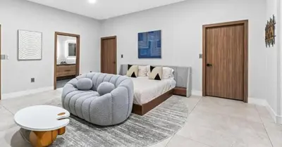 a bedroom with a bed and a couch and a chair at Waterfront Mansion The GlamHomes in North Miami Beach