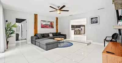 a living room with a couch and a ceiling fan at Miami's Exclusive Lagoon Villa in Miami