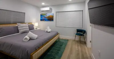 a bedroom with a large bed and a blue chair at New Oasis Waterfront & Sand Terrace THG in Miami