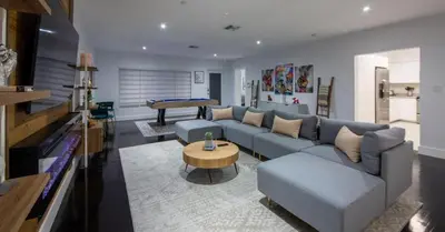 a living room with a blue couch and a table at New Oasis Waterfront & Sand Terrace THG in Miami