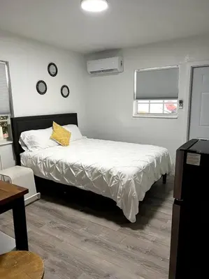 a bedroom with a bed with a yellow pillow on it at Nice and Cozy guest house in Miami