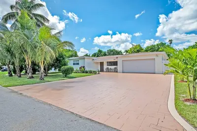 a house with palm trees and a driveway at Luxurious 5 bedrooms Jacuzzipool in Miramar