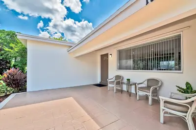 a patio with chairs and a table next to a building at Luxurious 5 bedrooms Jacuzzipool in Miramar
