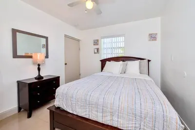 a bedroom with a bed with a dresser and a mirror at Luxurious 5 bedrooms Jacuzzipool in Miramar