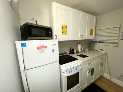 a kitchen with a white refrigerator and a microwave at Cozy & Colorful Miami Art Canvas w/HotTub & Murals in Miami