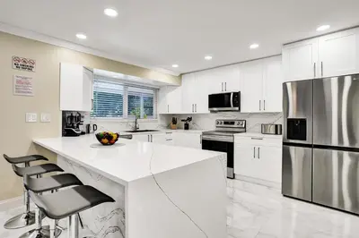 a kitchen with white cabinets and a large white island at Sensational 5BR Villa Heated Pool near Hard Rock in Hollywood