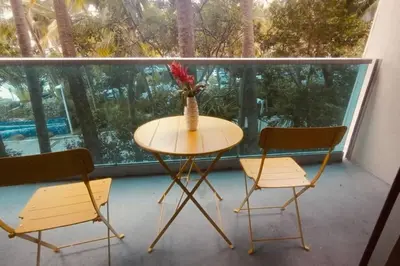 a table with two chairs and a vase of flowers on a balcony at SIAN private Apartments in Hollywood