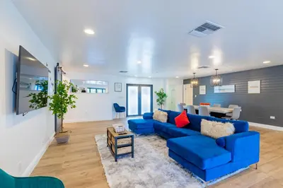 a living room with a blue couch and a table at Lakefront Villa and Paddle Board TGH in Miami