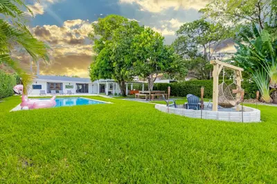 a yard with a pool and a playground at Lakefront Villa and Paddle Board TGH in Miami