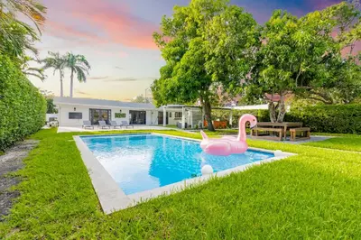 a swimming pool with a pink flamingo in a yard at Lakefront Villa and Paddle Board TGH in Miami