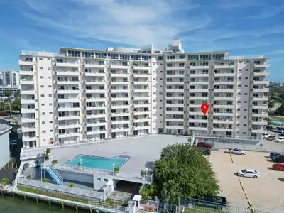 a large white building with a pool in front of it at Vista Mar: Bay Views Close to Miami Attractions in Miami Beach