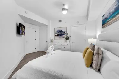 a white bedroom with a large white bed in a room at Modern 1 Bed in Downtown Doral With Free Parking in Hialeah Gardens