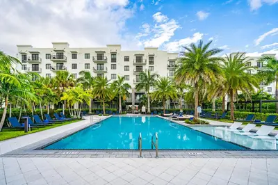 a hotel with a swimming pool in front of a building at Modern 1 Bed in Downtown Doral With Free Parking in Hialeah Gardens