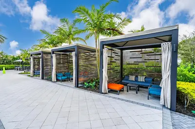 a pergola with benches and chairs in a garden at Modern 1 Bed in Downtown Doral With Free Parking in Hialeah Gardens
