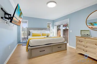 a bedroom with a bed with a dresser and a mirror at Beach Paradise, Family - Friendly, Free Parking in Hollywood