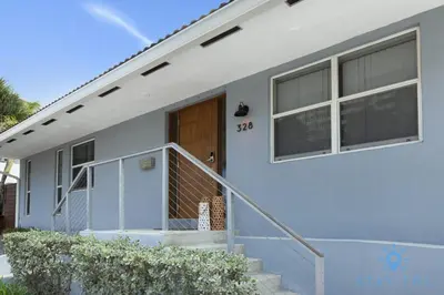 a white house with a wooden door and stairs at Beach Paradise, Family - Friendly, Free Parking in Hollywood