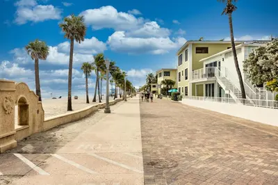 a cobblestone street next to a beach with palm trees at Beach Paradise, Family - Friendly, Free Parking in Hollywood
