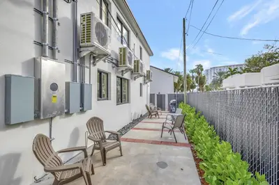 a patio with chairs and a fence and a building at Studio Right off Las Olas - Steps to FTL Beach 1C in Fort Lauderdale