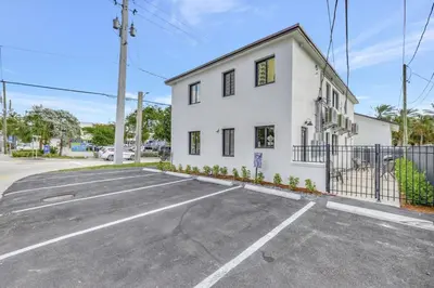an empty parking lot in front of a white building at Studio Right off Las Olas - Steps to FTL Beach 1C in Fort Lauderdale